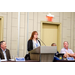  A woman with red hair standing behind a podium. 