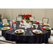  A dining table set up with a black table cloth, roses as a center piece, and ten place settings with salads and waters for guests. 