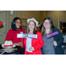  Shaunte Evans and two other women smiling as they hold up various signs that say Too Pretty for Murder, Whodunit, and Guilty. 