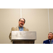  A man with glasses standing behind a podium. 