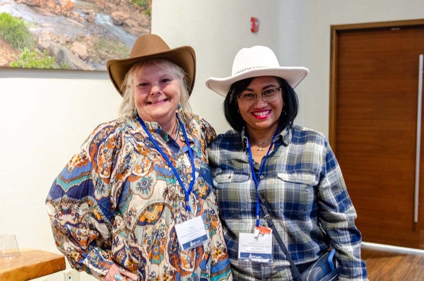 Two women in western clothing standing together for a photo.